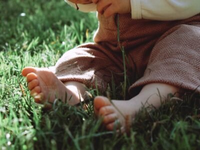 a small child sitting in the grass with a frisbee