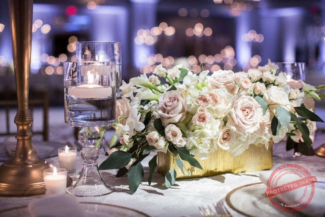 Luxurious wedding table setting with roses and candles, creating a romantic ambiance.
