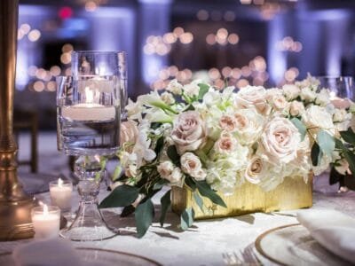 Luxurious wedding table setting with roses and candles, creating a romantic ambiance.