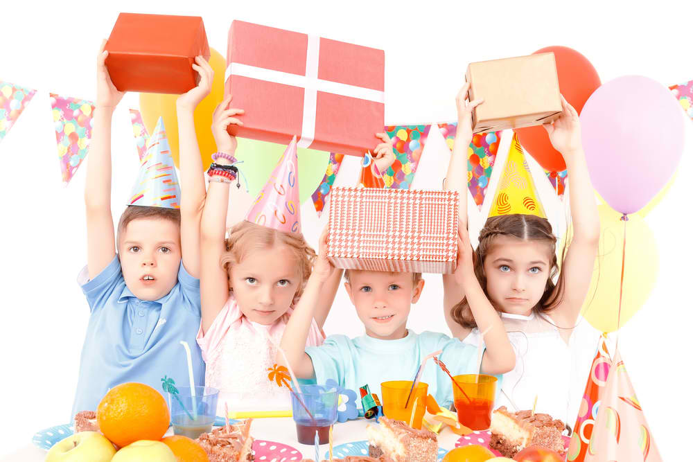 Little happy children lifting birthday presents during party Straipsniai.lt