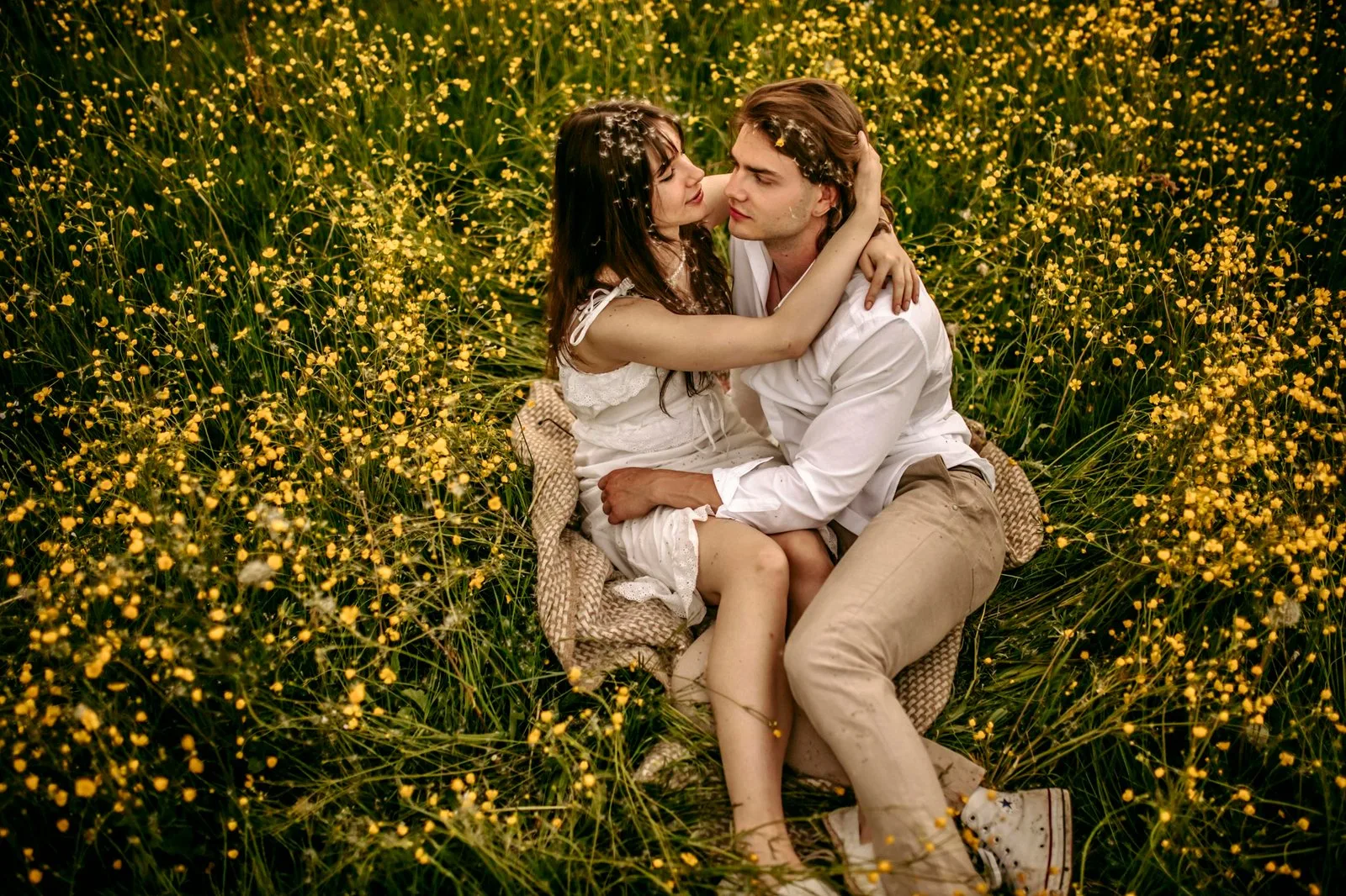 a couple embracing in a lush meadow filled with blooming yellow flowers during the day. 16681639 scaled 1 Straipsniai.lt