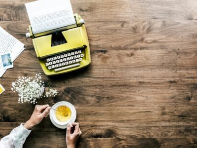 aerial-view-retro-typewriter-woman-with-cup-tea_53876-24822