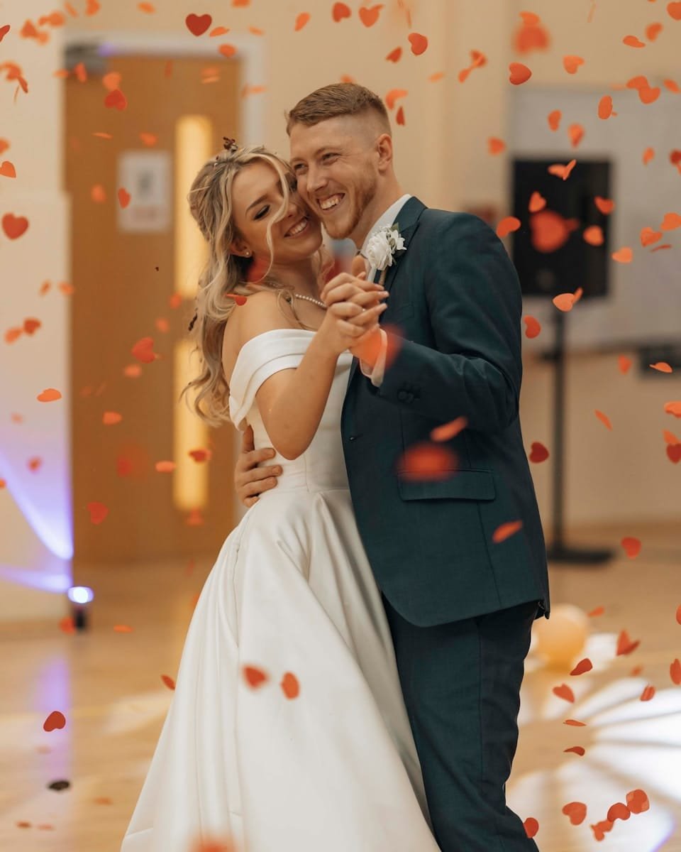 A bride and groom are posing for a picture