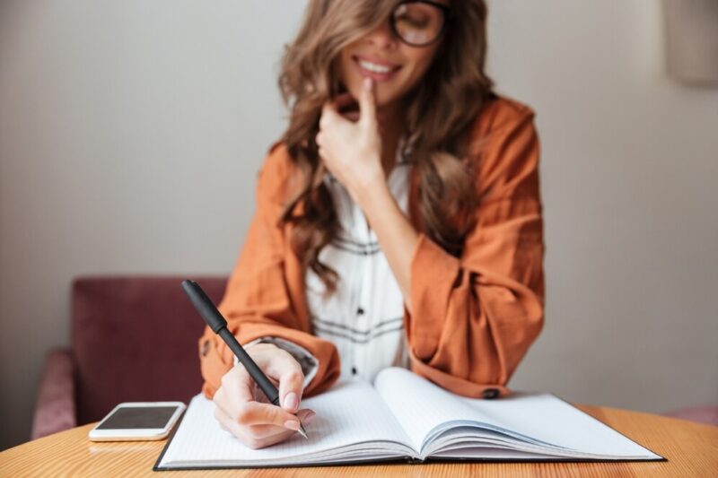 close-up-woman-taking-notes-notepad_171337-4051