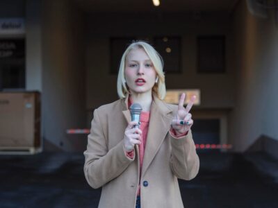 cropped-portrait-professional-female-reporter-work-young-woman-standing-street-with-microphone-hand-smiling-camera-horizontal-shot-selective-focus-woman_657921-903