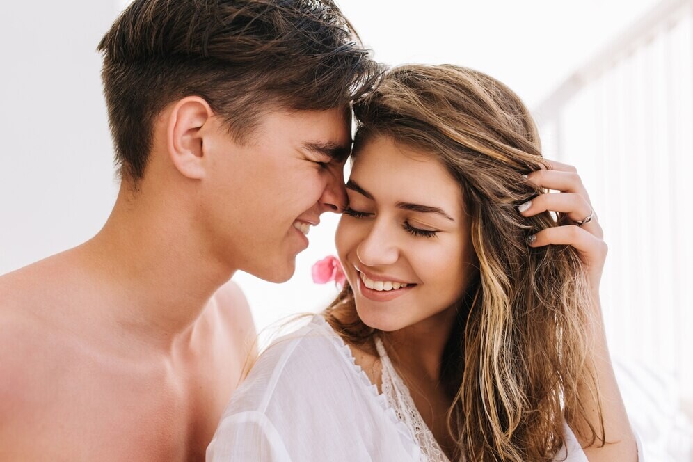 dreamy-girl-with-excited-smile-holding-her-hair-listening-love-confession-from-handsome-young-man-with-dark-short-hair-portrait-boy-his-girlfriend-spending-time-together-morning_197531-3222