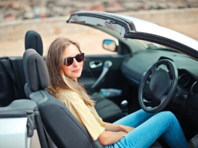 smiling woman sitting on black and white vehicle
