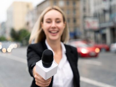 front-view-journalist-holding-microphone_23-2149032386