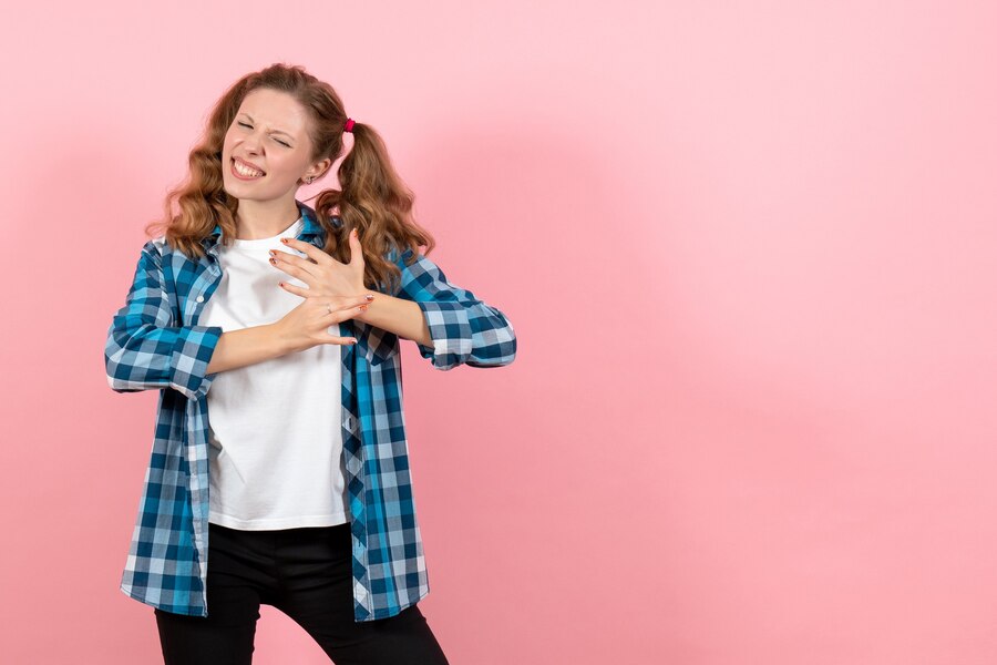 front view young female blue checkered shirt posing pink background kid youth emotion model woman color Straipsniai.lt