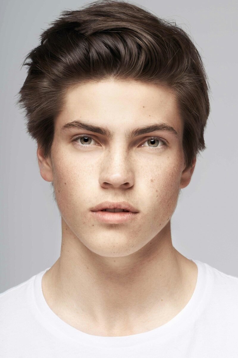 a young man with freckled hair and a white t - shirt