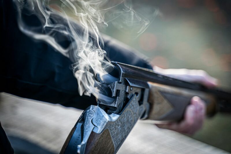 black semi automatic pistol with white smoke