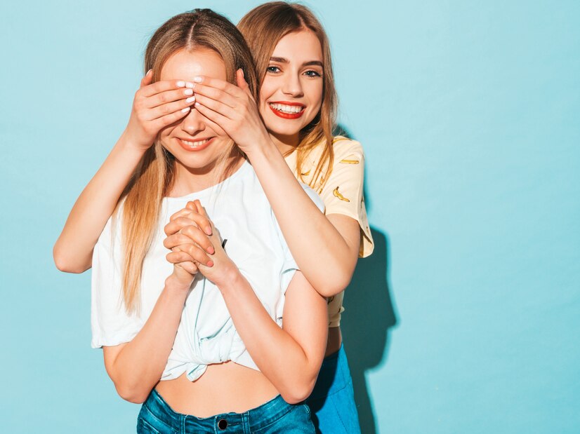 girl surprising her female best friend model covering her eyes hugging from Straipsniai.lt