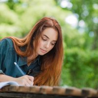 girl-writing-notebook-table_23-2147657103