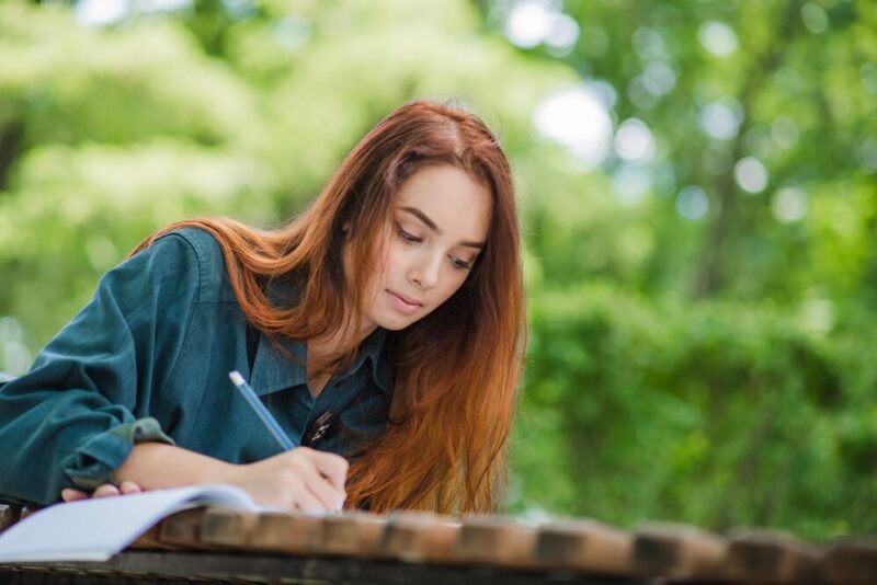 girl-writing-notebook-table_23-2147657103