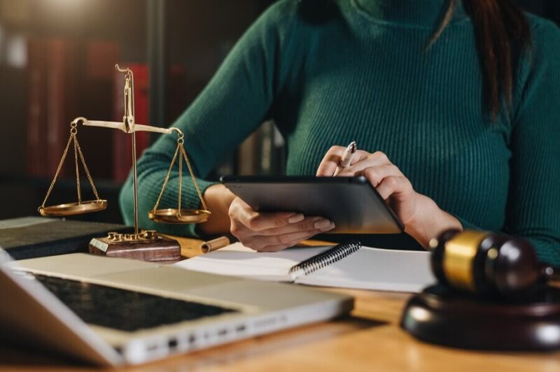 justice-law-concept-male-judge-courtroom-working-with-smart-phone-laptop-digital-tablet-computer-wood-table-morning-light_71455-31