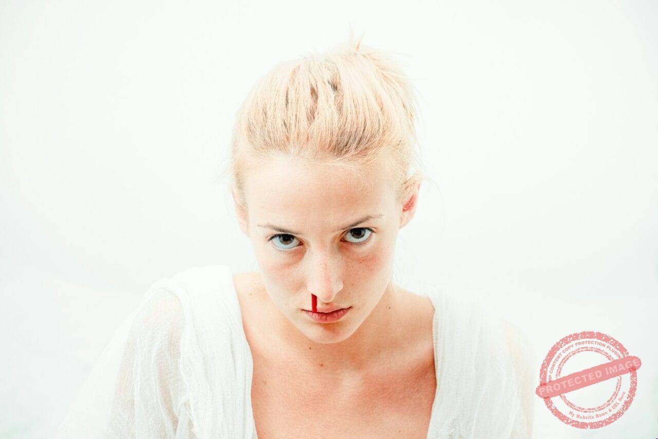 woman's bleeding nose with white background