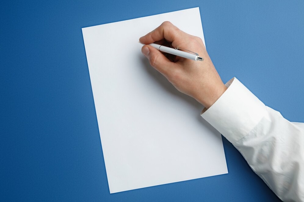 male-hand-holding-pen-writing-empty-sheet-blue_155003-30096