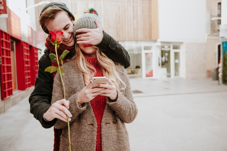 man closing eyes girlfriend giving rose Straipsniai.lt