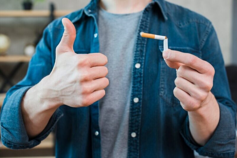 man-holding-broken-cigarette-showing-thumb-up-gesture_23-2148185357