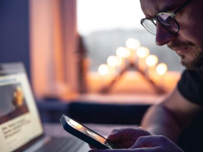 man-with-smartphone-sits-front-laptop-late-night_169016-27154