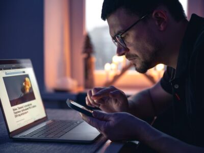 man-with-smartphone-sits-front-laptop-late-night_169016-27294