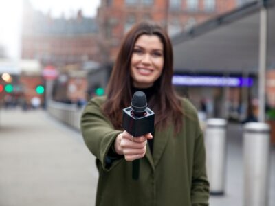 medium-shot-smiley-reporter-holding-microphone_23-2149267745