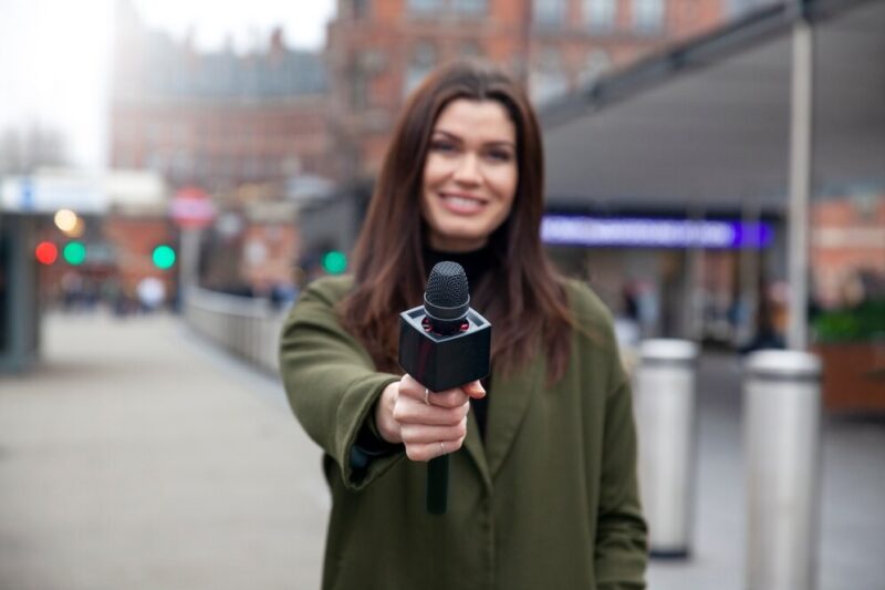 medium-shot-smiley-reporter-holding-microphone_23-2149267745