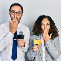 middle-age-couple-hispanic-woman-man-holding-reporter-microphones-covering-mouth-with-hand-shocked-afraid-mistake-surprised-expression_839833-32817