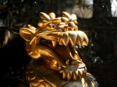 A golden statue of a dragon with its mouth open