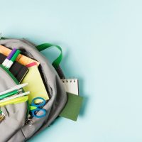opened-backpack-with-school-supplies_23-2148224209