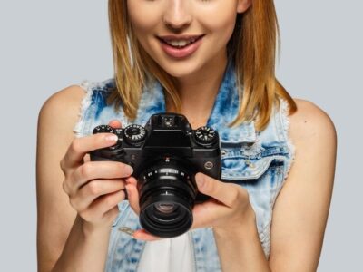 portrait-blond-female-photographer-isolated-grey-background_613910-9307