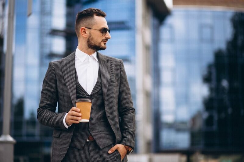 portrait-business-man-by-skyscraper-drinking-coffee