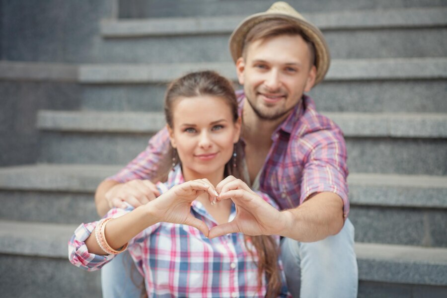 portrait young smiling people embracing tenderly bonding man woman making heart with their hands Straipsniai.lt