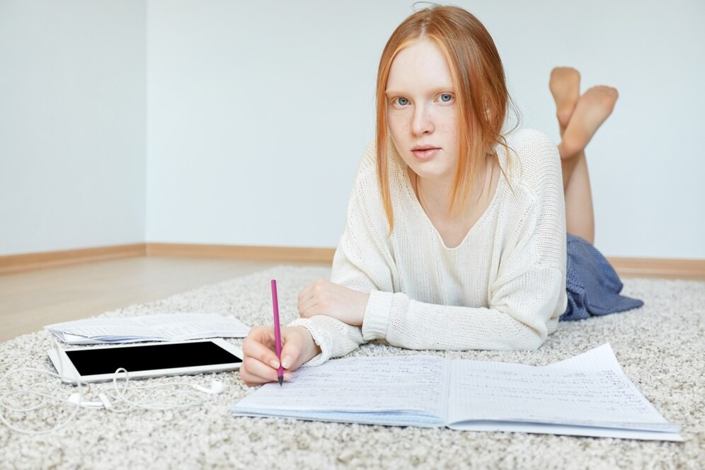 redhead-woman-lying-floor-with-notebook-tablet_273609-14456