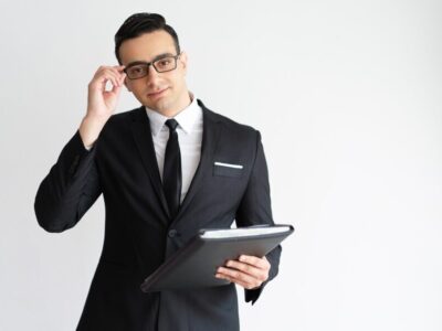 serious-handsome-young-businessman-adjusting-glasses-holding-folder_1262-14365