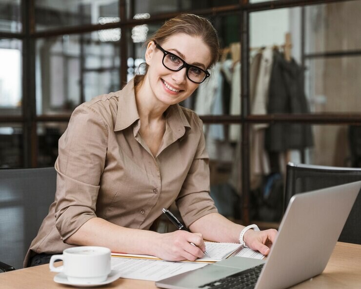 side-view-smiley-businesswoman-working-with-laptop-desk