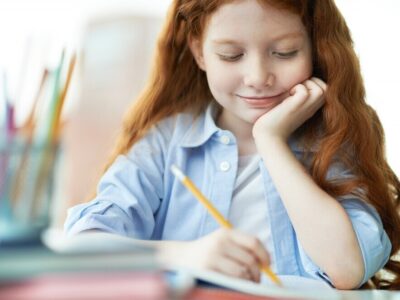 smiling-girl-finishing-her-homework_1098-469