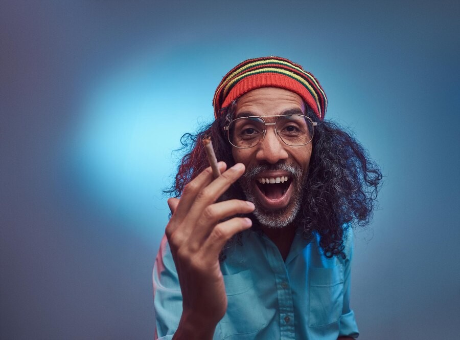 studio-portrait-african-rastafarian-male-smoking-cigarettes-isolated-blue-background_613910-2589