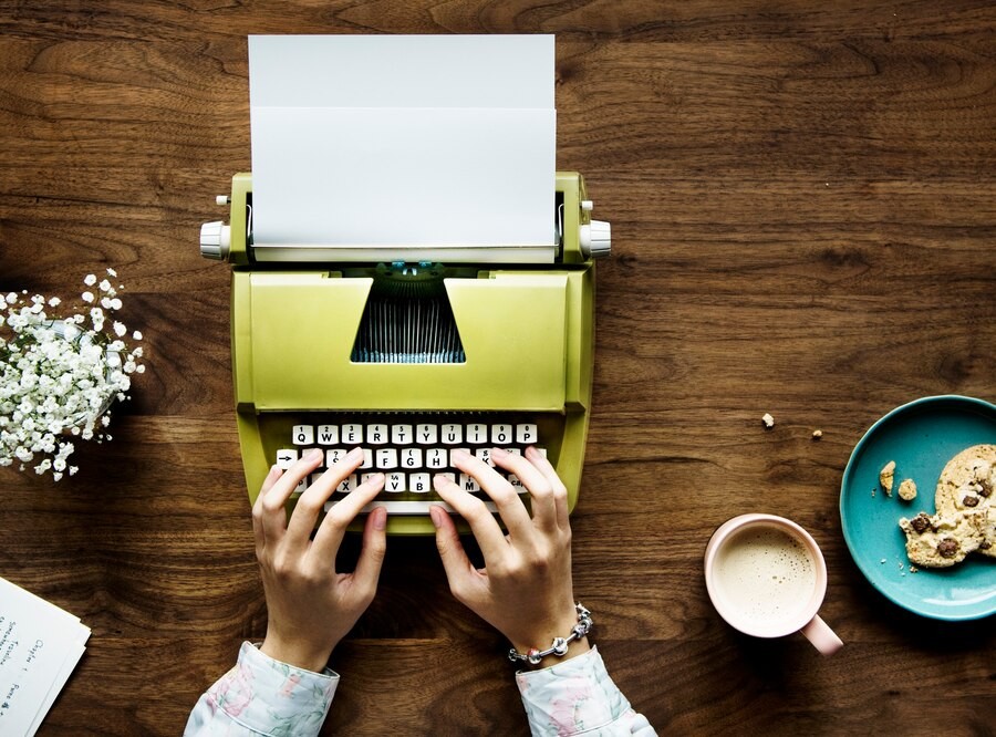 top-view-woman-typing-retro-typewriter-blank-paper_53876-94695