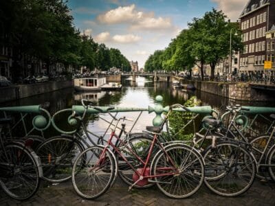 assorted-color bicycles park beside blue rails near river