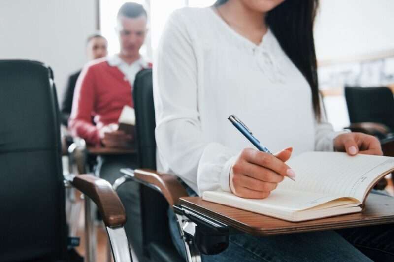 with-notepad-pen-hands-group-people-business-conference-modern-classroom-daytime_146671-16255