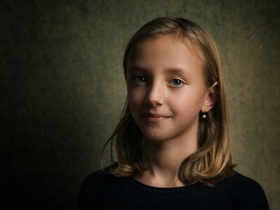 photo of girl standing near gray wall