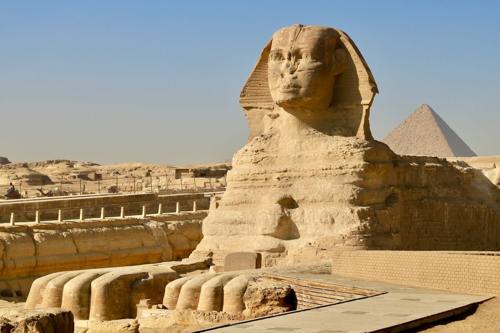 a large stone sculpture with Great Sphinx of Giza in the background