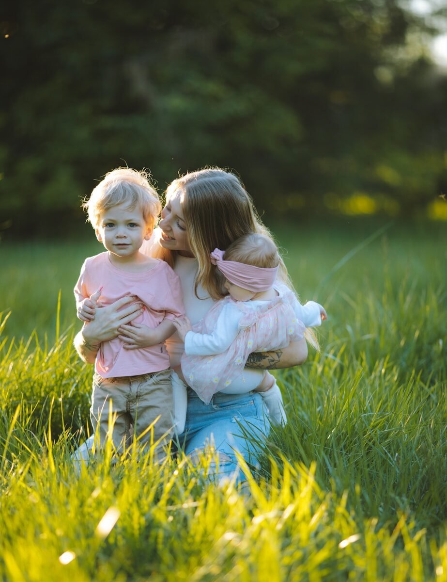 two little girls hugging each other in a field