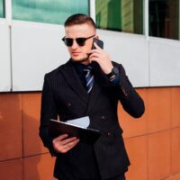 young-man-is-walking-down-street-talking-phone-managerial-position
