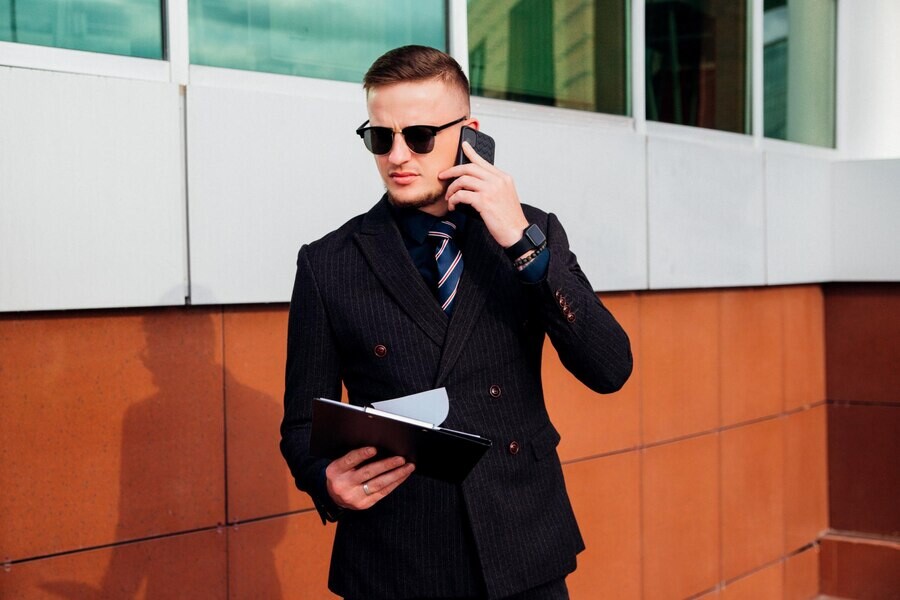 young-man-is-walking-down-street-talking-phone-managerial-position