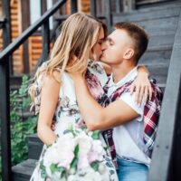 young-pretty-couple-kissing-near-new-wooden-home-celebrating-day-their-wedding-love-story_496169-2052