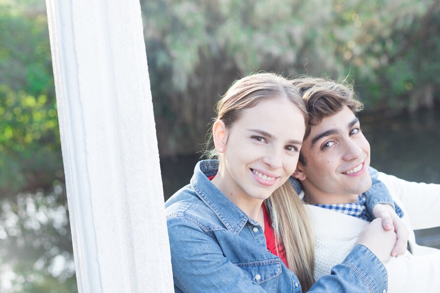 young woman wearing denim jacket hugging her boyfriend Straipsniai.lt