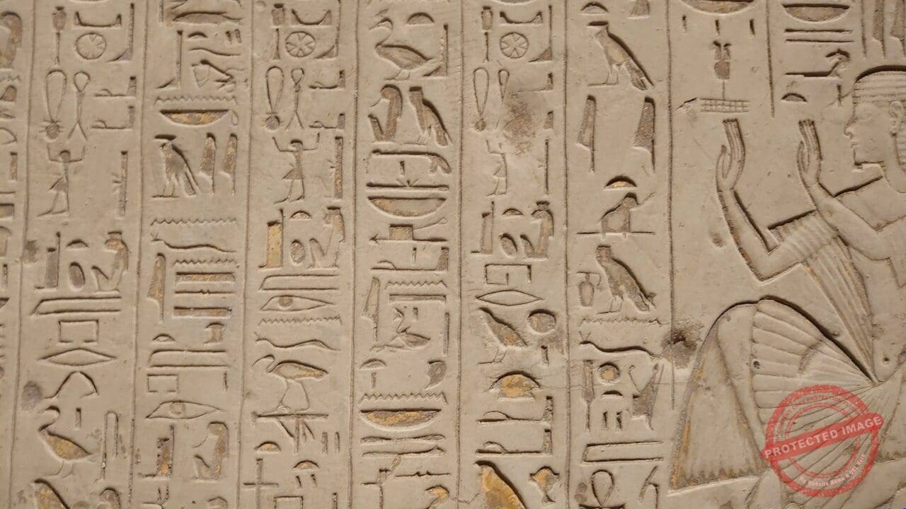 a close up of a wall with egyptian writing on it