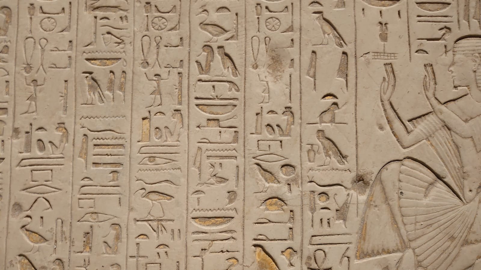 a close up of a wall with egyptian writing on it